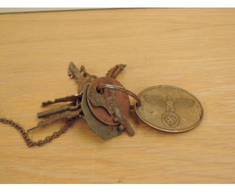 A German Gestapo Warrant Disc numbered 7597 on a key ring with two British Military Dog Tags and a metal Ring with Keys