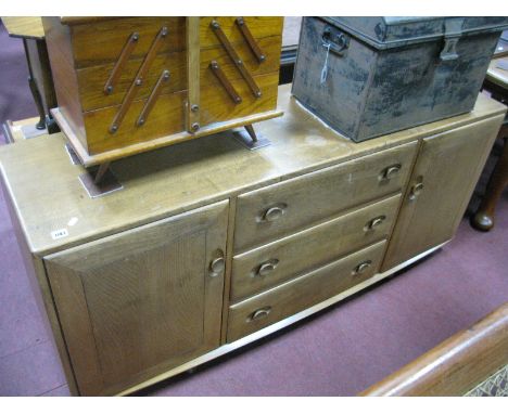 An Ercol Light Ash Sideboard, with cupboards, flanking three drawers, 155.5cm wide (top stained).