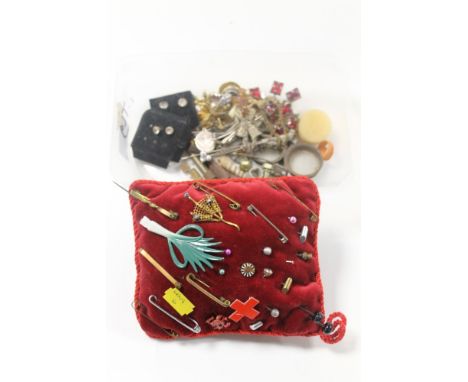 A PIN CUSHION WITH COSTUME JEWELRY AND STICK PINS 
