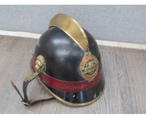 An early-mid 20th Century Austrian Fireman's helmet with Wegscheid A/K Feuerwehr badge, black leather covered with brass cres
