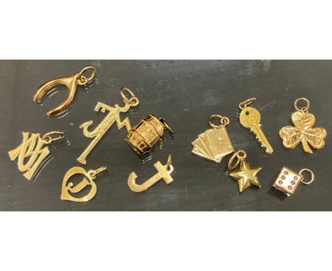 A 9ct gold charm, as a dice, black spots, others wish bone, playing cards, barrel, key, letter J, various  marks, 4.7g gross,