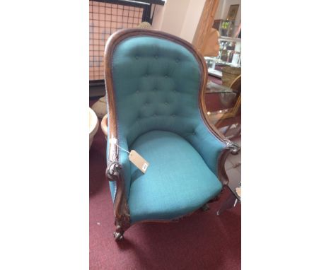 A Victorian rosewood spoon back armchair, having turqouise button back upholstery, floral carved armrests, raised on cabriole