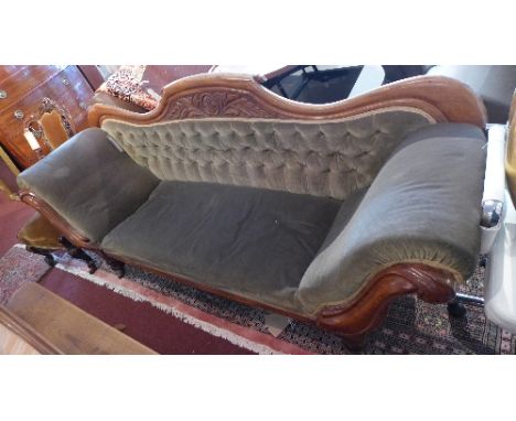 A Victorian mahogany scroll end sofa, with green velour button back upholstery, raised on turned legs and castors 