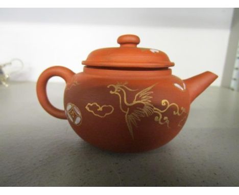 A Chinese terracotta small teapot with gilt phoenix and floral decoration having white enamel highlights, incised seal mark t