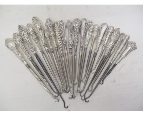 Twenty Victorian and later silver and white metal handled button hooks, each with embossed decoration 
