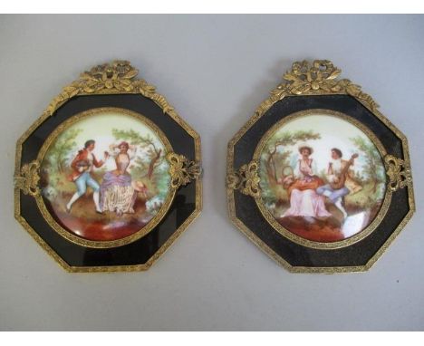 A pair of early 20th century portrait miniatures, each of a man and woman sitting on a mound of grass by trees, on porcelain,