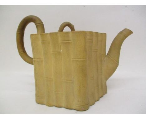 A late 18th century Chinese buff coloured stoneware teapot modelled as a bundle of cut bamboo, with a flat lid, bamboo finial