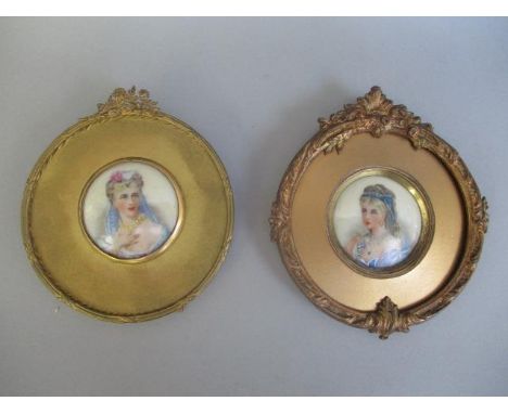 Two late 19th/early 20th century head and should portrait miniatures, each of a woman wearing jewels and a dress on porcelain