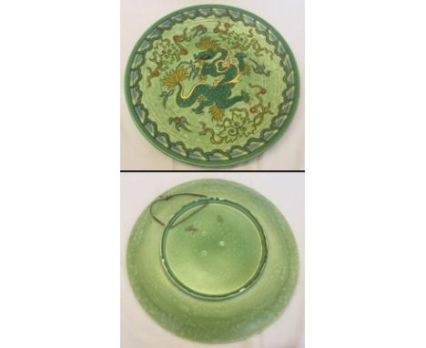 A large ceramic Charlotte Rhead charger with dragon design. Green, yellow and gold colouration. 43 cm diameter