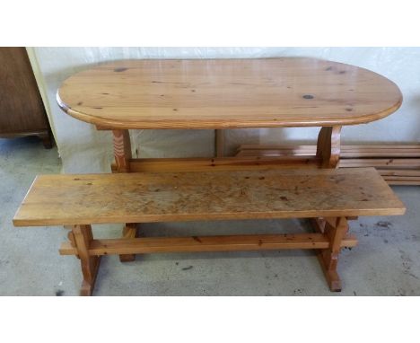 An oval pine kitchen table with pine bench.  Table 145 x 74cm, bench 146cm long.