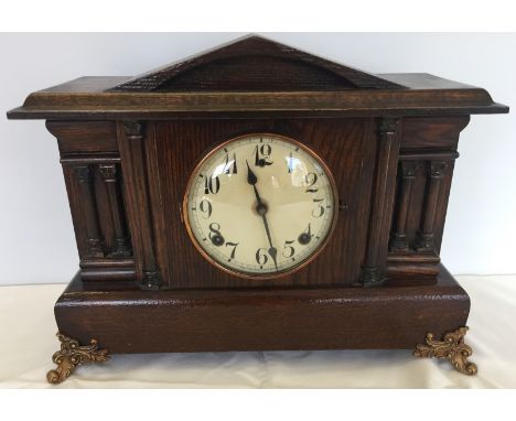 Vintage American chiming oak mantle clock. With column detail to the front and decorative gilded metal feet. Cream dial.  Wit