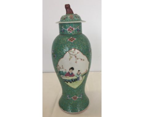 A decorative Chinese ceramic lidded jar with painted panels on a turquoise background.  Measures approx. 31cm tall.