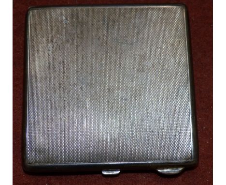 A silver square powder compact with engine turned decoration