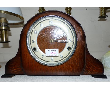 A 1930's mantel clock in oak Napoleon hat case