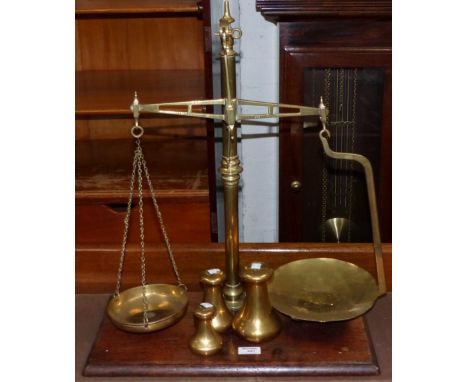 A 19th century brass balance scale on mahogany plinth, 3 graduating bell weights 7lb - 2lb, 6 circular weights 2lb - ½ oz