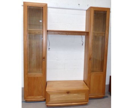 A modern Ercol light elm wall unit with 2 tall glazed side cabinets, central shelf and TV stand