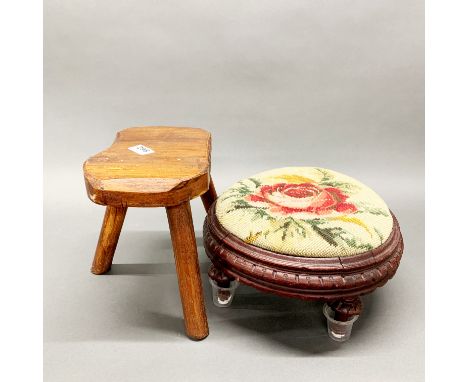 A tapestry covered foot stool with a small milking stool.