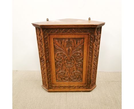 A carved oak wall corner shelf, H. 52cm D. 29cm.