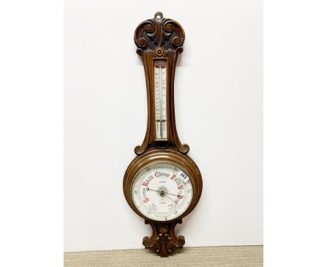 A carved oak wall barometer.
