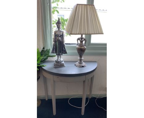 A grey painted half moon hall table, a silver coloured Buddha ornament and a table lamp with shade (3)