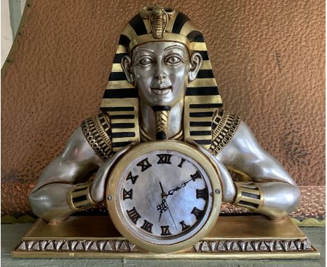 A fibre glass silver and gilt Pharaoh mantel clock 66cm wide 