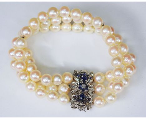 Dreireihiges Perlenarmband mit 18 K Weißgold gestempelte Schmuckschließe in Blumenform. Diese ist von kleinen Diamanten und h