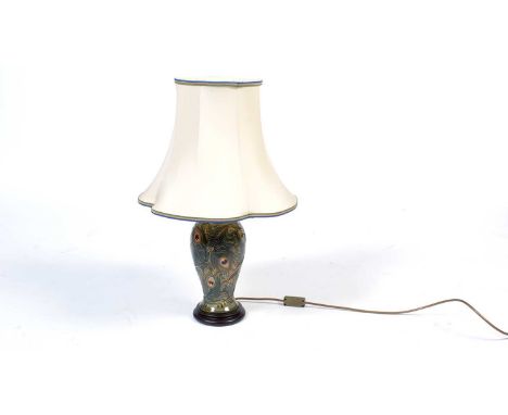 A Moorcroft peacock feather pattern table lamp base, fitted with wooden base and brass fittings, cream quatrefoil fabric shad