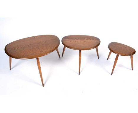 Ercol: a model 354 beech and elm set of 'Pebble' nesting tables, with shaped top raised on tapered spindle supports, the larg