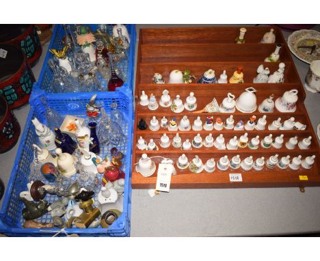 A collection of mainly modern glass and ceramic ornamental bells; animal ornaments on two plastic trays; and a display unit.
