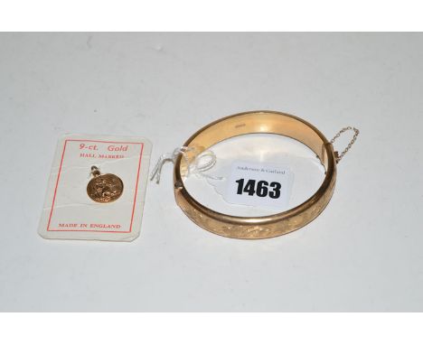 A 9ct. bangle half engraved with leaf design, 18grms; together with a St. Christopher charm.