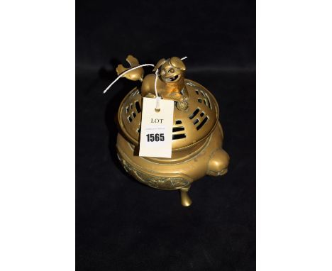 A 20th Century Chinese brass incense burner, Dog of Fo finial, raised on tripod feet, signed.