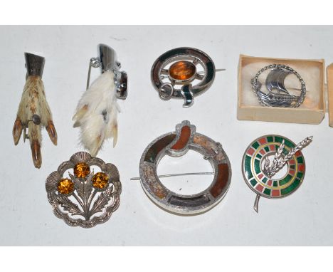 A quantity of Scottish style white metal brooches, some set stones, one enamel; claw pattern brooches; and a galleon pattern 