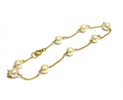 A MARKED K14 FINE LINK CHAIN CULTURED PEARL BRACELET  the bracelet set with eight cultured pearls on a yellow metal fine link