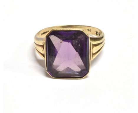 A VINTAGE 9CT GOLD PURPLE SAPPHIRE (SYNTHETIC) COCKTAIL RING The step cut faceted stone measuring approx. 14 x 12 mm, on a ye