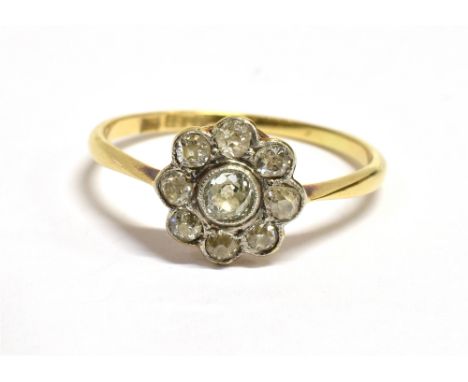 AN ART DECO 18CT GOLD DIAMOND DAISY RING the daisy comprising eight outer old cut diamonds with a central old cut diamond mea