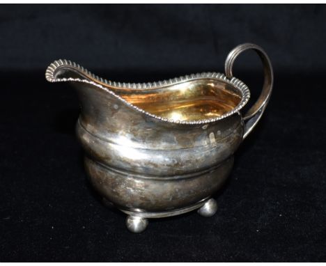 A GEORGE III SILVER SAUCE BOAT  the boat on four ball feet with patterned rim, hallmarked for London 1811 (leopard's head cro