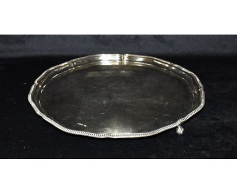 A SILVER SALVER  the salver with ribbed pie crust border on three ball feet, hallmarked for London 1975, maker RP, diameter 3