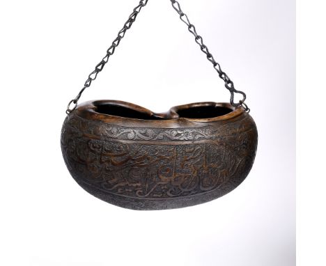 A Qajar carved large coco de mer hermit flask (kashkul) 19th/20th Century with Islamic calligraphy to one side, the front wit