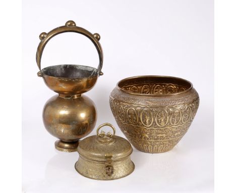 An Indian brass lidded casket engraved with repeating flower pattern, handle finished with dog heads, 24cm diameter,  a brass