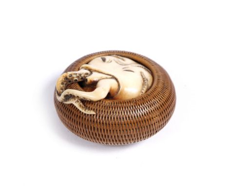 A Japanese netsuke of Manju form 19th Century finely woven in basket work and containing an ivory octopus