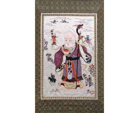 A Chinese embroidered silk study of Shou Lao First half 20th Century within a fabric border, 50cm x 81cm, overall size 67cm x