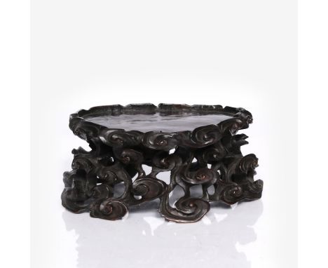 A Chinese hardwood lingchi stand 19th Century of open scroll form, 25cm across, 11cm high