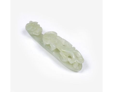 A Chinese pale green jade belt buckle 19th Century carved and undercut with a chi dragon and with a chi dragon head hook, 6.8