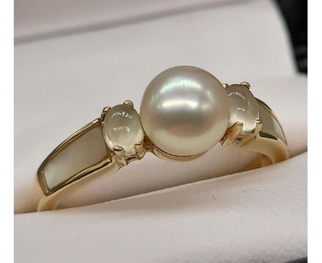 A Ladies 9ct gold ring set with a single pearl setting off set by mother of pearl shoulders. [Ring size T] [3.08Grams] 