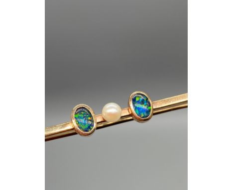 An Antique 9ct gold bar brooch set with a single pearl off set by a single black opal to either side. [3.58grams] 