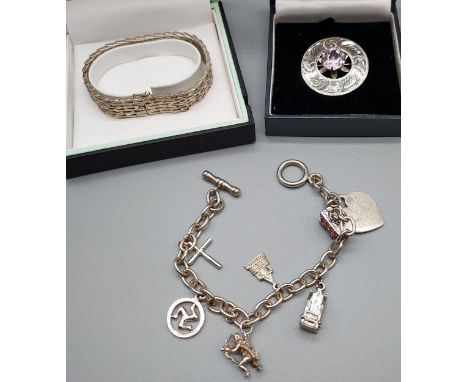 An Edinburgh silver plaid brooch [3.5cm in diameter], A London silver gate bracelet and charm bracelet. 