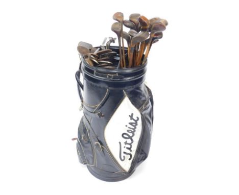 A large Titleist golf or display bag, containing a collection of vintage drivers, mainly wooden shafted, and a selection of w