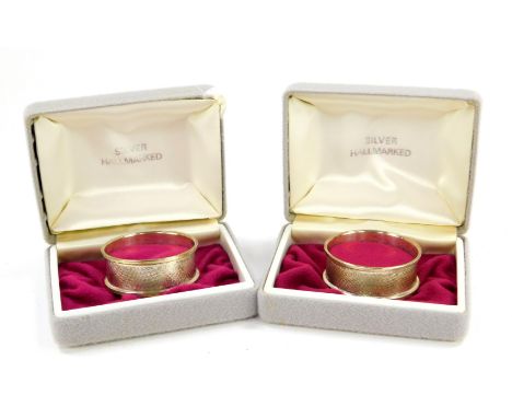 A pair of silver napkin rings, with engine turned decoration, rectangular reserve, boxed, Birmingham 1985, 0.72oz.