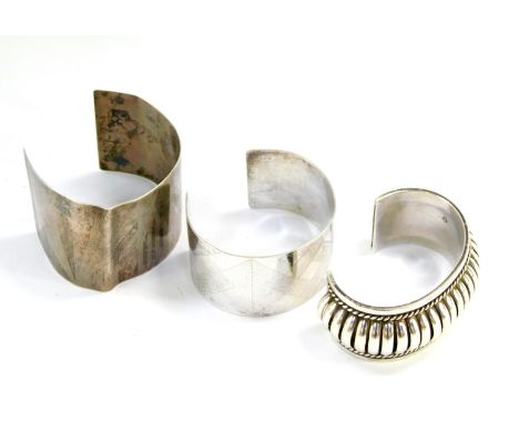 Two NBH silver cuff bangles, with engine turned decoration, together with a PA open work fluted silver cuff bangle, 5.27oz.