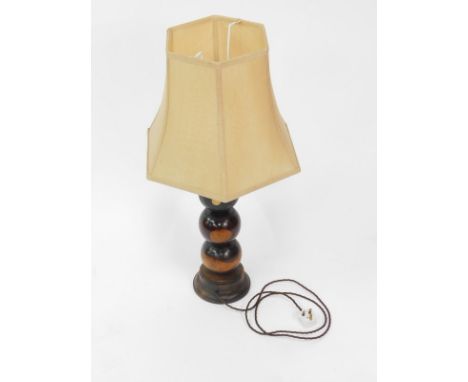 A wooden table lamp, formed as four lignum vitae bowls raised on an oak circular base, with shade, 83cm high.